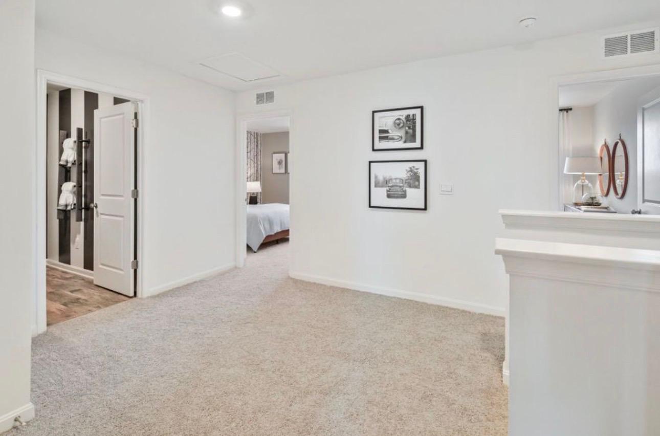 The Frederick Retreat upstairs hallway with carpeted floors and doorways to the bedrooms and a bathroom