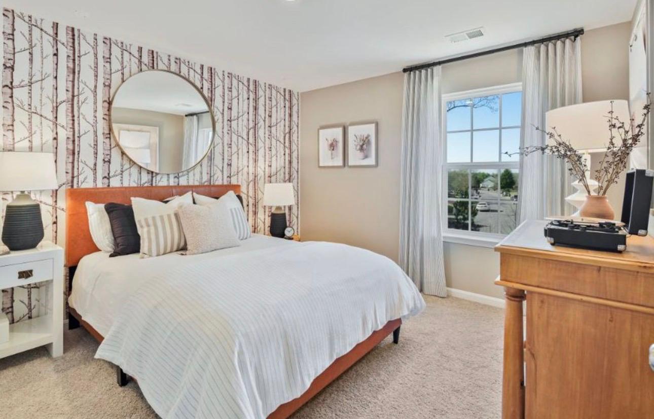 Guest bedroom with a bed, leather headboard, and a birch-tree pattern accent wall at The Frederick Retreat
